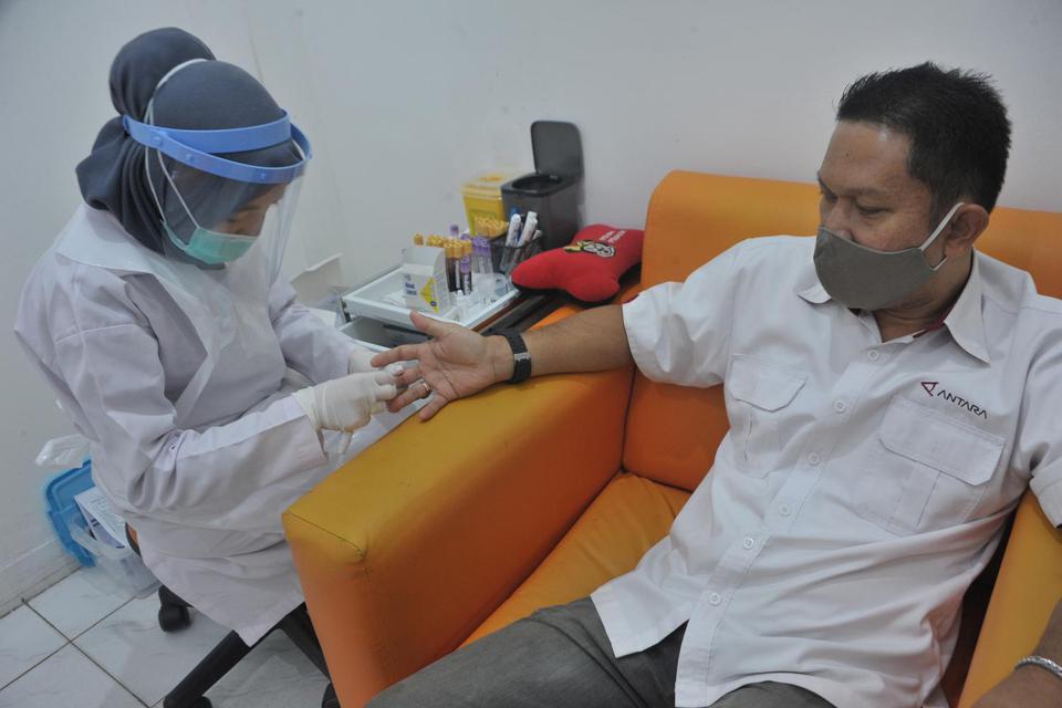 Petugas kesehatan mengambil sampel darah salah satu jurnalis Antara pada rapid test massal bagi karyawan LKBN ANTARA di Laboratorium Kimia Farma Palembang, Sumsel, Rabu (30/9/2020). Rapid test yang diselenggarakan serentak di seluruh biro LKBN Antara se-