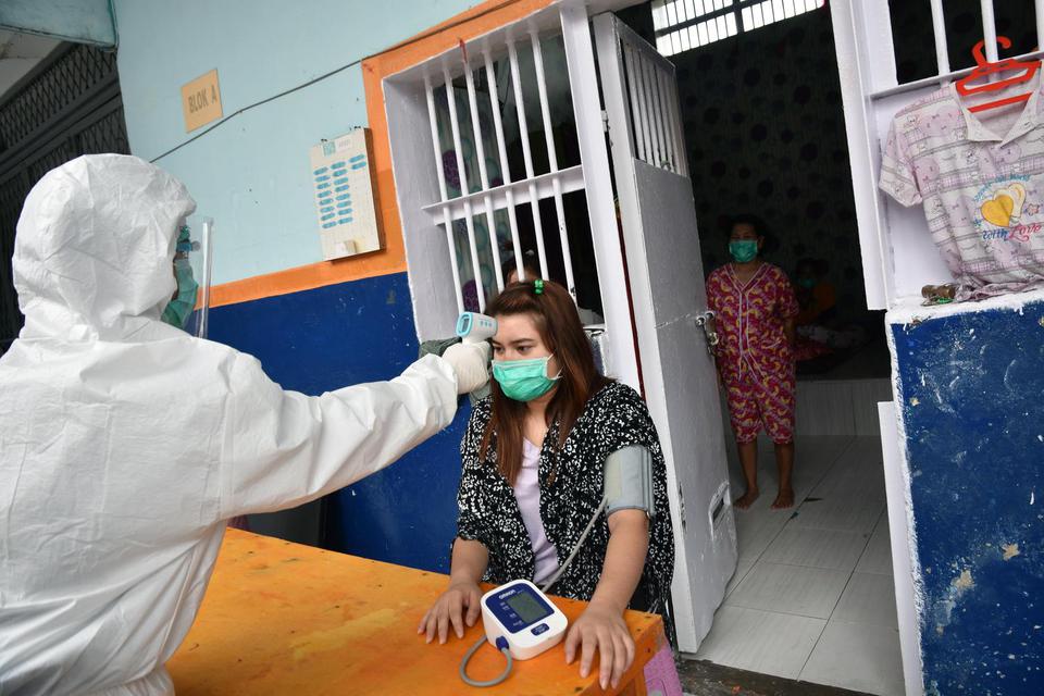 Petugas Lembaga Pemasyarakatan (Lapas) Perempuan Kelas IIA Pekanbaru mengenakan alat pelindung diri saat memeriksa kesehatan warga binaan yang positif COVID-19, di Kota Pekanbaru, Riau, Kamis (1/10/2020). Lapas Perempuan Pekanbaru kewalahan akibat klaster