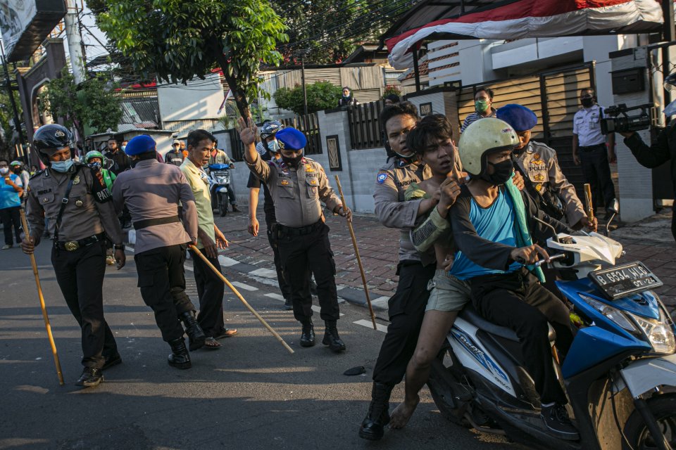 Petugas menangkap massa yang melakukan aksi protes tolak pengesahan RUU Cipta Kerja di Kawasan Palmerah, Jakarta Pusat, Rabu (7/10/2020). Aksi tersebut menolak pengesahan UU Cipta Kerja yang telah disahkan oleh DPR RI karena dinilai sudah menciderai hak-h