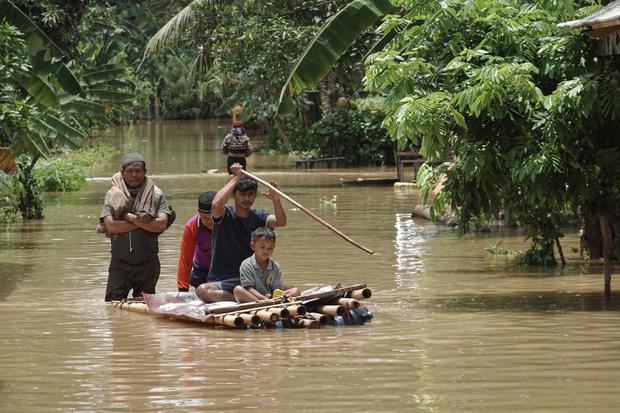 Warga menggunakan rakit darurat untuk melakukan evakuasi dari rumah yang terendam banjir di Desa Gentasari, Kroya, Cilacap, Jawa Tengah, Selasa (27/10/2020). Hujan deras yang mengguyur wilayah selatan Jateng akibat dampak dari fenomena La Nina, selama dua