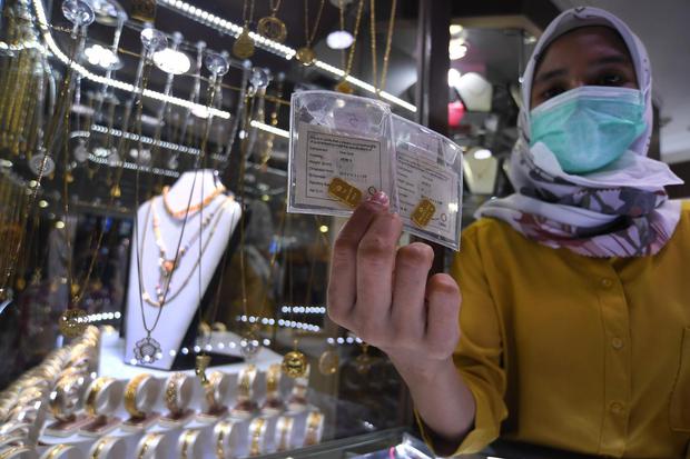 Karyawan menunjukkan kepingan harga emas di Toko Mas International, Pasar Mayestik, Jakarta, Selasa (3/11/2020). Harga jual logam mulia PT Aneka Tambang (Persero) Tbk pada perdagangan hari ini naik Rp.10.000 ke level Rp.1.004.000. 