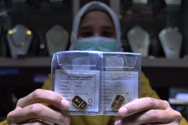 Karyawan menunjukkan kepingan harga emas di Toko Mas International, Pasar Mayestik, Jakarta, Selasa (3/11/2020). Harga jual logam mulia PT Aneka Tambang (Persero) Tbk pada perdagangan hari ini naik Rp.10.000 ke level Rp.1.004.000.
