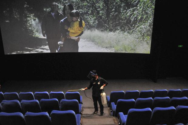 Petugas menyemprotkan cairan disinfektan sebelum pengunjung memasuki area bioskop di Kota Cinema Mall, Jatiasih, Bekasi, Jawa Barat, Kamis (5/11/2020). Pemerintah setempat mengizinkan pengelola bioskop untuk kembali beroperasi dengan kapasitas penonton ma