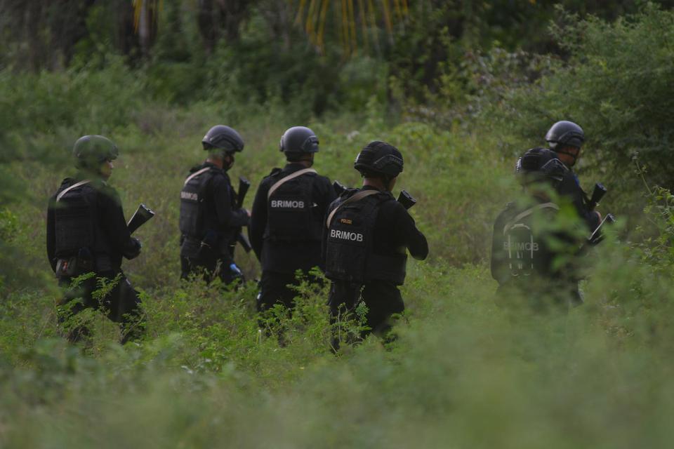 Personel Brimob Polri melakukan penyisiran pada lokasi yang diduga menjadi lokasi persembunyian saat melakukan pengejaran terhadap terduga teroris di Kelurahan Mamboro, Palu Utara, Sulawesi Tengah, Sabtu (7/11/2020).