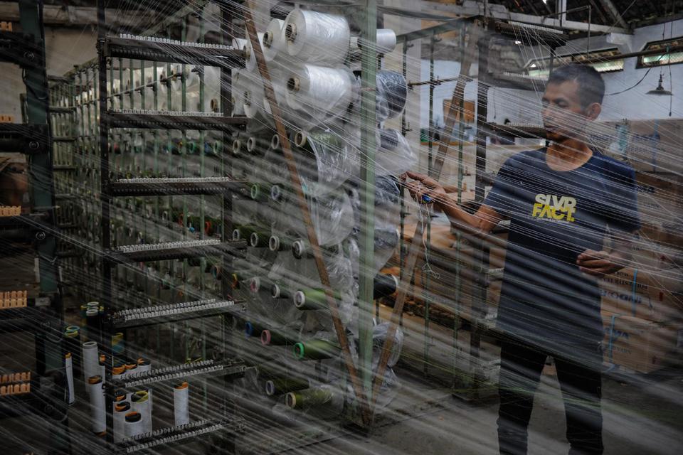 Pekerja menyelesaikan pemintalan benang di pabrik pembuatan sarung di Majalaya, Kabupaten Bandung, Jawa Barat, Senin (9/11/2020). Dinas Ketenagakerjaan dan Transmigrasi Provinsi Jawa Barat mencatat, sebanyak 19.089 pekerja dari 460 perusahaan tekstil tela