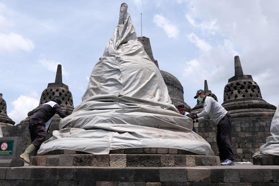 Sejumlah pekerja menutup stupa menggunakan terpaulin di kompleks candi Borobudur, Magelang, Jateng, Rabu (11/11/2020). Penutupan candi Borobudur oleh Balai Konservasi Borobudur (BKB) sebagai langkah antisipasi melindungi batu candi dari abu vulkanik jika 