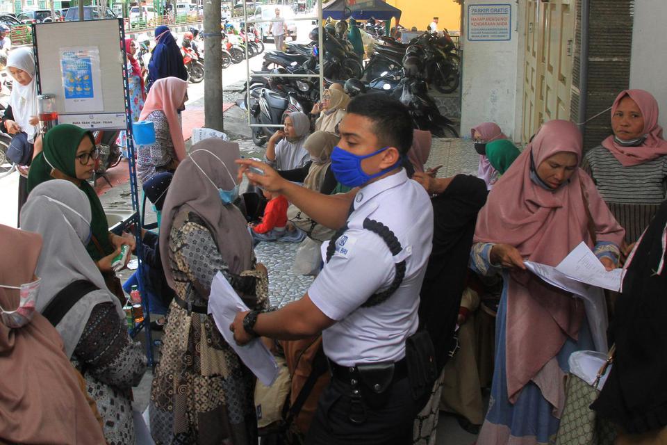 Sejumlah pelaku usaha antre mengambil Bantuan Langsung Tunai (BLT) UMKM di Bank Rakyat Indonesia (BRI) cabang Meulaboh, Aceh Barat, Aceh, Selasa (8/12/2020). Sebanyak 993 UMKM yang terdampak pandemi COVID-19 di kabupaten setempat, menerima BLT senilai Rp 