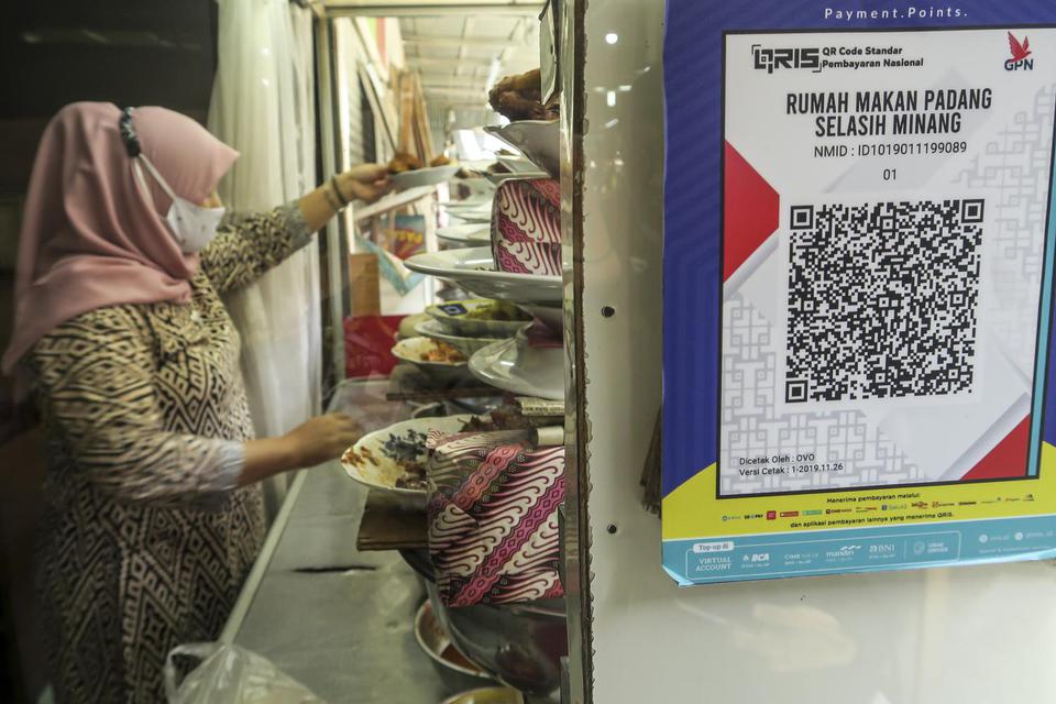 Sebuah kode batang (QR barcode) transaksi nontunai terpasang di rumah makan, di Jakarta, Jumat (18/12/2020). Bank Indonesia (BI) memperpanjang kebijakan gratis biaya transaksi nontunai yang dibebankan ke toko (Merchant Discount Rate/MDR) alias nol persen 