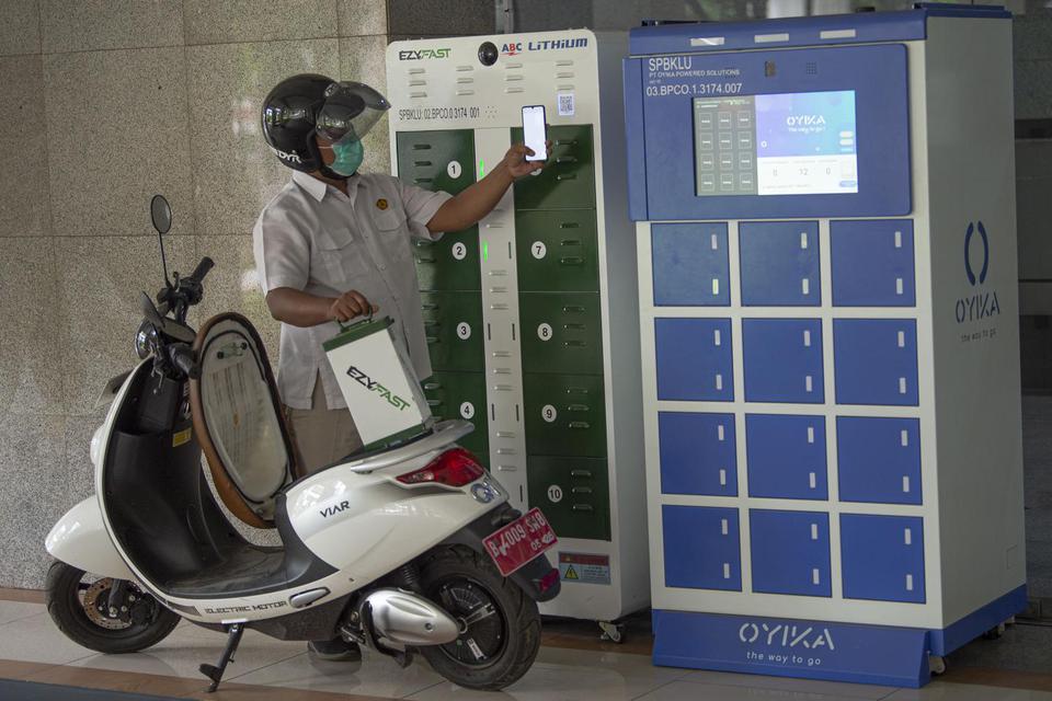 Karyawan mengganti baterai sepeda motor listrik di Stasiun Penukaran Baterai Kendaraan Listrik Umum (SPBKLU), Gedung Direktorat Ketenagalistrikan Kementerian Energi dan Sumber Daya Mineral (Kementerian ESDM), Jakarta, Senin (21/12/2020). 