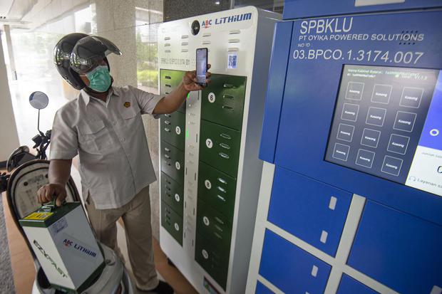 Karyawan mengganti baterai sepeda motor listrik di Stasiun Penukaran Baterai Kendaraan Listrik Umum (SPBKLU), Gedung Direktorat Ketenagalistrikan Kementerian Energi dan Sumber Daya Mineral (Kementerian ESDM), Jakarta, Senin (21/12/2020). Kementerian ESDM 