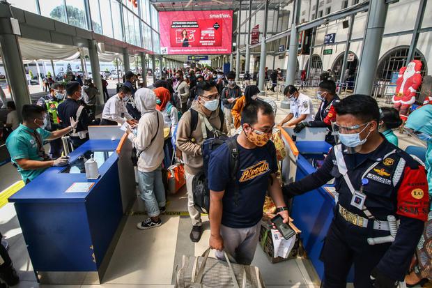 Penumpang antre untuk memasuki area peron di memasuki Stasiun Pasar Senen, Jakarta, Jumat (25/12/2020). PT Kereta Api Indonesia telah menjual 428.000 tiket KA untuk periode masa libur Natal dan Tahun Baru 2021 keberangkatan 18 Desember 2020 - 6 Januari 