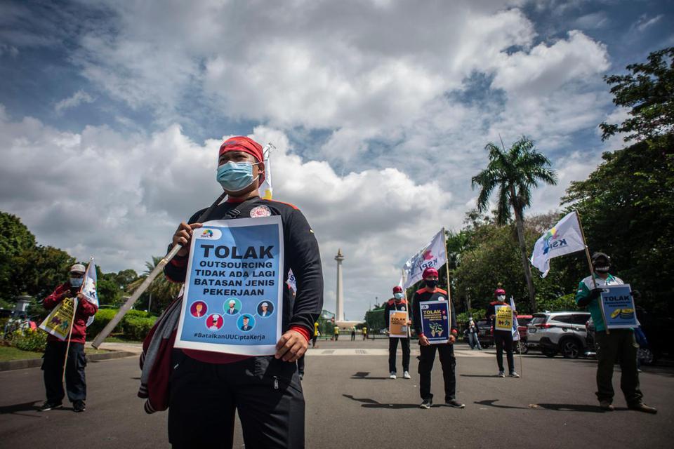 Massa dari Konfederasi Serikat Pekerja Indonesia (KSPI) melakukan aksi unjuk rasa di kawasan kawasan Patung Kuda Arjuna Wiwaha, Jakarta, Selasa (29/12/2020). Aksi tersebut bertujuan untuk menolak UU Cipta kerja dan meminta pemerintah menaikkan UMSK 2021.