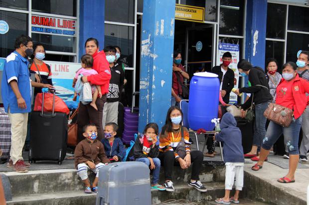 Sejumlah pemudik dari Kepulauan Riau menunggu angkutan bus tujuan Medan di Pelabuhan Bandar Sri Junjungan Dumai di Dumai, Riau, Selasa (29/12/2020). Jumlah pemudik Natal dan Tahun Baru (Nataru) 2021 dari Kepulauan Riau yang singgah di Pelabuhan Dumai per 