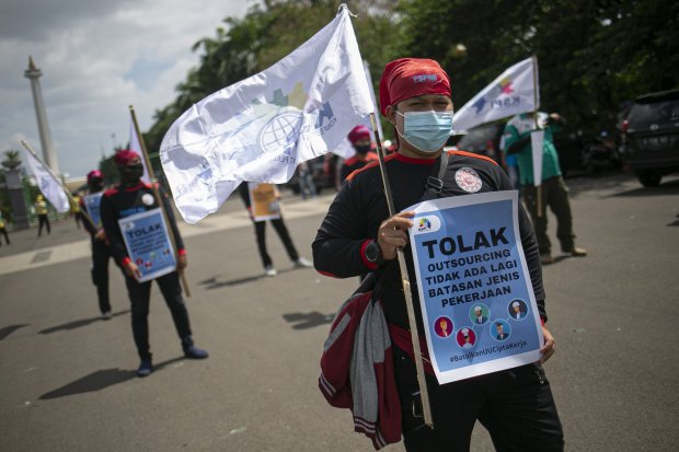 Sejumlah massa buruh yang tergabung dalam Konfederasi Serikat Pekerja Indonesia (KSPI) melakukan aksi unjuk rasa di kawasan Patung Kuda Arjuna Wiwaha, Jakarta, Selasa (29/12/2020). Aksi unjuk rasa yang serentak dilaksanakan di 18 daerah tersebut menyuarak
