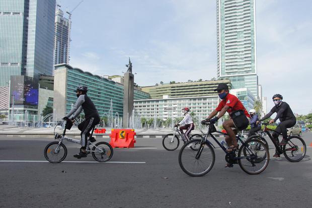 Warga bersepeda melintasi kawasan Bundaran HI, Jakarta, Minggu (3/1/2021). Meski Car Free Day belum diberlakukan karena Pemprov DKI masih memperpanjang Pembatasan Sosial Berskala Besar (PSBB), sejumlah warga tetap berolahraga melintasi jalan Sudirman - Th