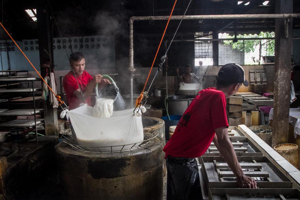 Perajin tahu memproduksi tahu berbahan kedelei di desa Krajan, Mojosongo, Solo, Jawa Tengah, Senin (4/1/2021). Menurut perajin mereka terpaksa mengurangi jumlah produksi hingga mengurangi ukuran tahu akibat naiknya harga kacang kedelei impor yang semula R