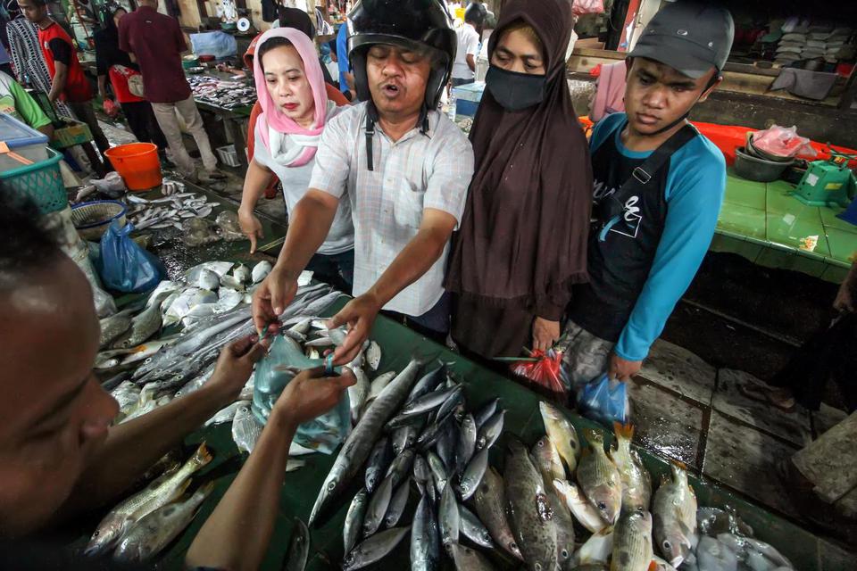Pedagang melayani pembeli ikan segar di pasar tradisional Lhokseumawe, Aceh, Selasa (5/1/2021).