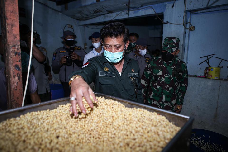 Menteri Pertanian Syahrul Yasin Limpo meninjau tempat produksi tempe saat operasi stabilitas harga kedelai di Semanan, Jakarta, Kamis (7/1/2021). Dalam operasi pasar tersebut, kedelai dijual ke perajin seharga Rp8.500 per kilogram dan diupayakan bertahan 