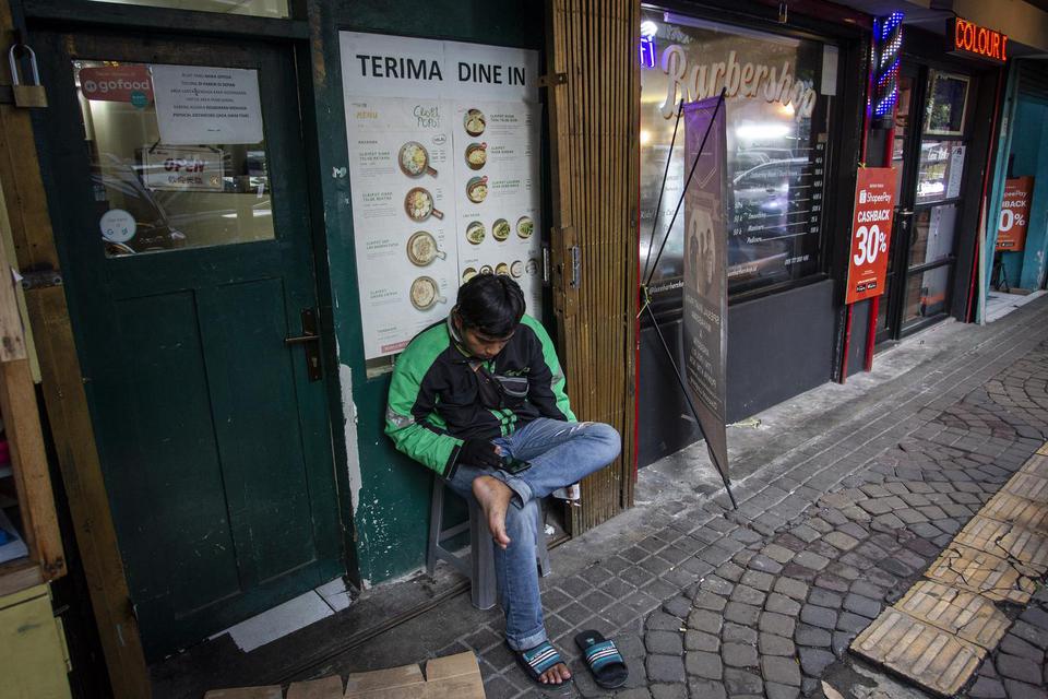 Pengemudi ojek daring menunggu pesanan di depan salah satu restoran di kawasan Sabang, Jakarta, Jumat (8/1/2021). Pemerintah menetapkan kebijakan Pemberlakuan Pembatasan Kegiatan Masyarakat (PPKM) di wilayah Jawa-Bali pada 11-25 Januari mendatang guna men