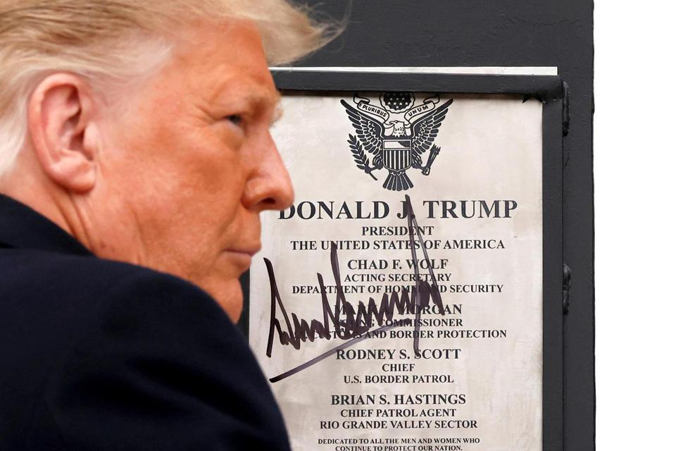 Carlos Barria Presiden AS Donald Trump menandatangani plakat yang ditempatkan di dinding perbata AS-Meksiko t kunjungannya di Alamo, Texas, AS, Sela(12/1/2021).