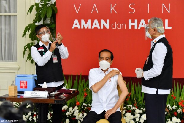 Presiden Indonesia Joko Widodo melakukan vaksinasi Covid-19 di Istana Negara, Rabu (13/1/2021).