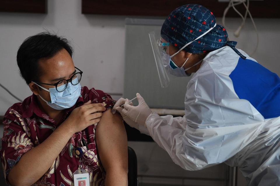 Petugas medis menyuntikan vaksin COVID-19 ke seorang dokter di RS Siloam TB Simatupang, Jakarta, Kamis (14/1/2021). Program vaksinasi COVID-19 tahap pertama kepada tenaga kesehatan mulai dilakukan di berbagai daerah di Indonesia.