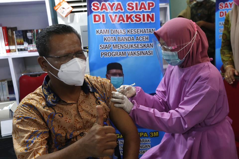 Kepala Dinas Kesehatan Kota Banda Aceh Lukman mendapatkan suntikan vaksin COVID-19 pada hari pertama vaksinasi untuk pejabat Forum Koordinasi Pimpinan Daerah (Forkopimda) Kota Banda Aceh di RSUD Meuraxa, Banda Aceh, Aceh, Jumat (15/1/2021). Pemerintah dae