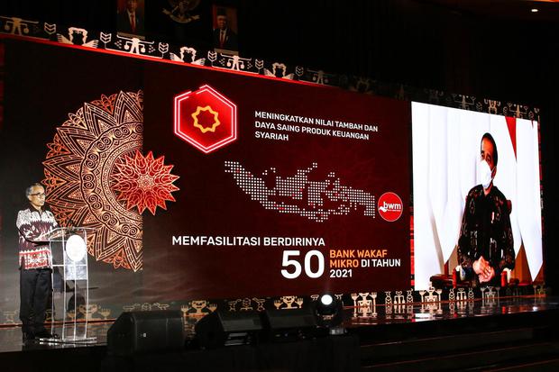 Ketua Dewan Komisioner OJK Wimboh Santoso (kiri) memberikan sambutan yang disaksikan secara virtual oleh Presiden Joko Widodo (kanan) saat pertemuan tahunan OJK di Jakarta, Jumat (15/1/2021). OJK sudah menyiapkan berbagai kebijakan stimulus lanjutan untuk