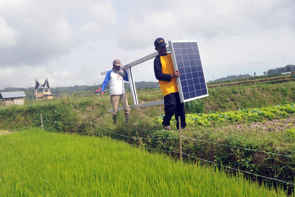 Petani memindahkan panel tenaga surya untuk dipasang di kawasan pertanian Le Marsi di Nagari Pandai Sikek, Kabupaten Tanah Datar, Sumatra Barat.