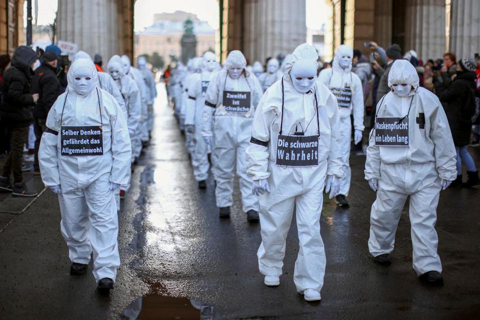 Lisi Niesner Para pengunjuk raberjas putih dan mengenakan topeng menghadiri demonstrasi melawan tindakan virus corona (COVID-19) dan konsekuensi ekonomi mereka di Wina, Austria, Sabtu (16/1/2021).