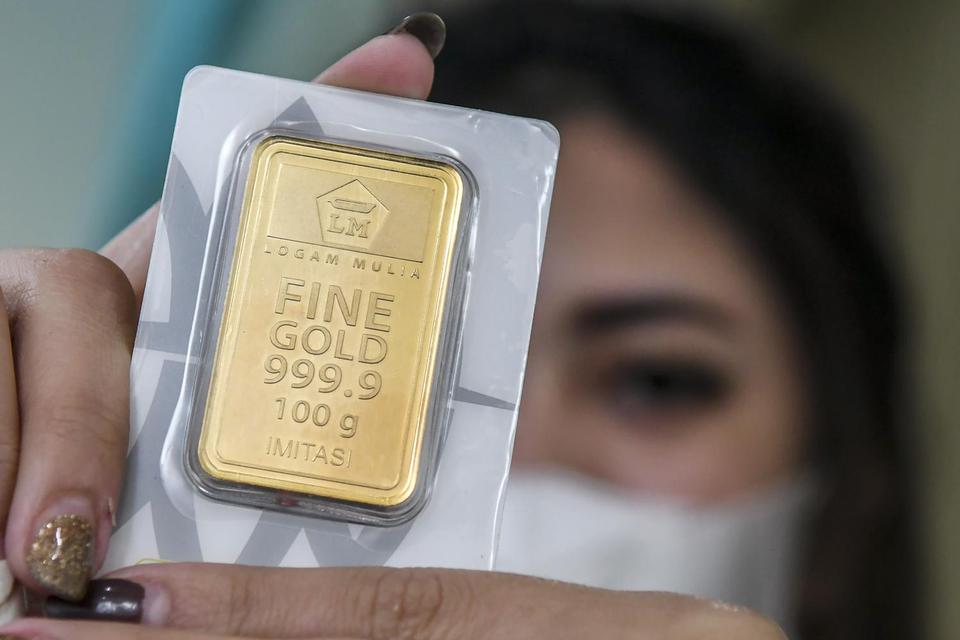 Karyawan menunjukan harga emas batangan di Butik Emas Antam, Kebon Sirih, Jakarta, Senin (18/1/2021). Harga emas PT Aneka Tambang (Persero) Tbk pada Senin (18/1) berada pada posisi Rp 944.000 per gram atau turun Rp4.000 dari perdagangan akhir pekan lalu.