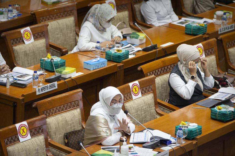 Menteri Tenaga Kerja (Menaker) Ida Fauziyah (kiri) menyampaikan paparan saat rapat kerja bersama Komisi IX DPR di kompleks Parlemen, Jakarta, Senin (18/1/2021). Agenda rapat tersebut salah satunya membahas tentang perkembangan peraturan turunan Undang-und