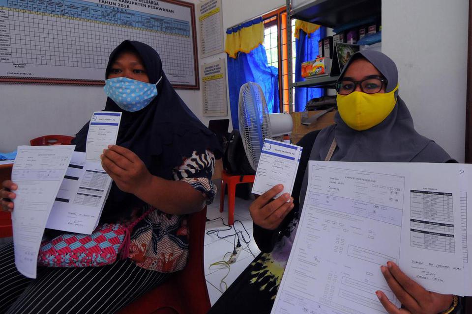 Calon akseptor memperlihatkan kartu peserta KB layanan Metode Kontrasepsi Jangka Panjang (MKJP) di Balai Penyuluh KB Kecamatan Teluk Pandan, Kabupaten Pesawaran, Lampung, Rabu (20/1/2021). Pemasangan implant merupakan pelayanan rutin yang dilakukan Badan 