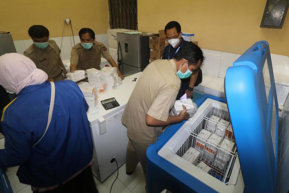 Petugas memasukkan vaksin COVID-19 Sinovac ke dalam lemari pendingin saat tiba di gudang farmasi Dinas Kesehatan Kota Kediri, Jawa Timur, Senin (25/1/2021) malam. Dinas Kesehatan daerah setempat menerima sebanyak 3.680 dosis vaksin tahap pertama untuk ten