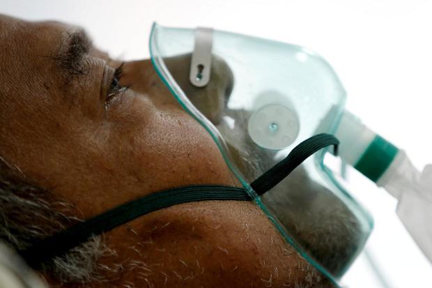 Willy Kurniawan Seorang pasien menderita penyakit virus korona (COVID-19) bernapas dengan masker non-rebreather dalam sebuah ruang isolasi di sebuah rumah sakit di Bogor, Indonesia, Selasa (26/1/2021).