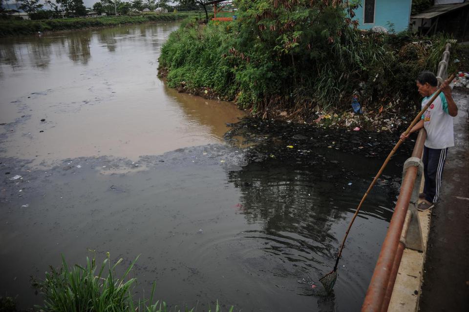 Warga mengambil sampah di muara pertemuan antara Sungai Citepus dan Sungai Citarum yang tercemar limbah di Cangkuang, Kabupaten Bandung, Jawa Barat, Rabu (27/1/2021). Warga setempat mengeluhkan air di muara Sungai Citarum yang masih tercemar limbah dan me