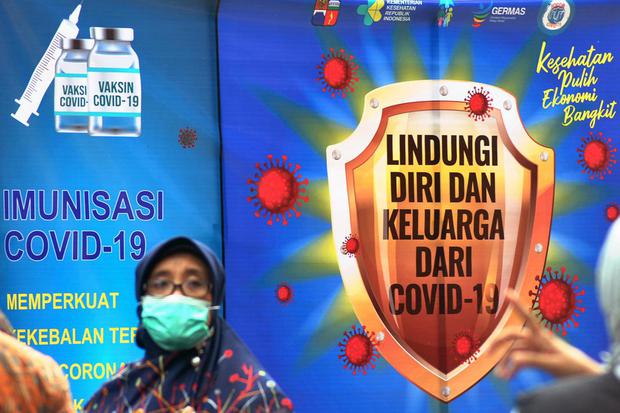 Warga melewati baliho sosialisasi vaksinasi COVID-19 di Kota Bogor, Jawa Barat, Kamis (28/1/2021). Sosialisasi vaksinasi COVID-19 tersebut bertujuan untuk meyakinkan masyarakt bahwa vaksin aman dan menunjukkan tingginya antusiasme untuk divaksin sebagai u