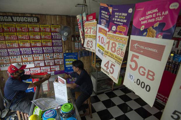 Warga membeli pulsa telepon seluler di salah satu toko di Jakarta, Sabtu (30/1/2021). Menteri Keuangan Sri Mulyani Indrawati menegaskan penerbitan Peraturan Menteri Keuangan (PMK) 06/PMK.03/2021 tidak berdampak dengan adanya pungutan baru untuk pulsa, vou