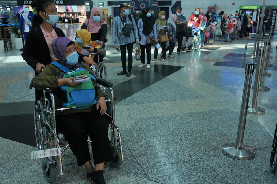 Sebanyak 166 Pekerja Migran Indonesia (PMI) bersiap pulang ke Surabaya dengan menggunakan pesawat carter Citilink QG 8553 dari Kuala Lumpur International Airport (KLIA) di Kuala Lumpur, Sabtu (30/1/2021). Mereka mengikuti Program Rekalibrasi Pulang pemeri