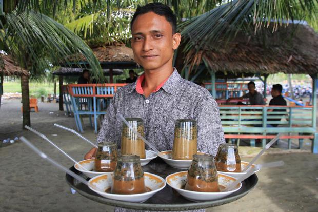 Ilustrasi, pelayan membawa kopi terbalik (kopi khop) khas Meulaboh pesanan pengunjung di salah satu warung kopi tradisional di Aceh. Membuka warung kopi bisa menjadi usaha sampingan karyawan yang menarik untuk dijalankan.