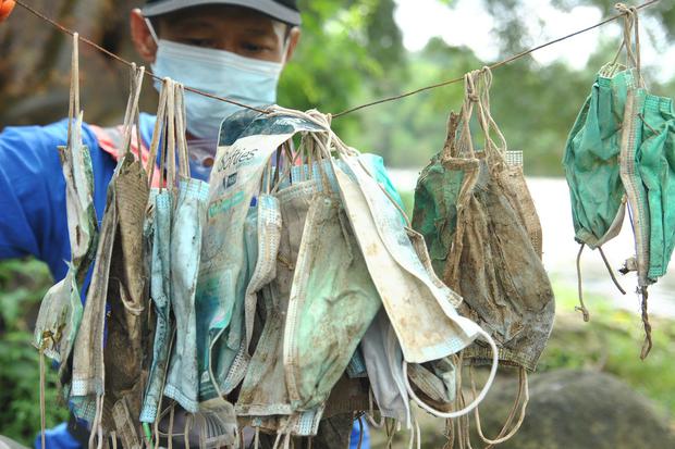 Anggota satgas naturalisasi Ciliwung Kota Bogor mengumpulkan sampah masker medis bekas pakai, di bantaran sungai Ciliwung, Kelurahan Sukaresmi, Kota Bogor, Jawa Barat, Rabu (3/2/2021). Sebanyak 40 sampah masker medis ditemukan di bantaran sungai Ciliwung 