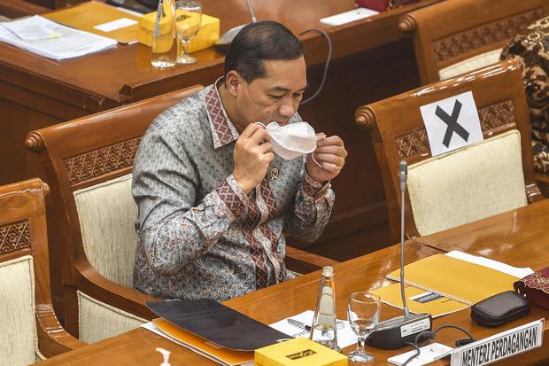 Menteri Perdagangan Muhammad Lutfi menggunakan masker saat akan menyampaikan paparan pada Rapat Dengar Pendapat (RDP) dengan Kepala BKPM dan Komisi VI DPR di Kompleks Parlemen, Senayan, Jakarta, Rabu (3/2/2021). Rapat tersebut membahas mengenai rencana ke