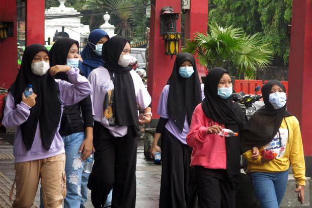 Warga menggunakan masker saat melintasi Jalan Surya Kencana, Kota Bogor, Jawa Barat, Minggu (7/2/2021). Data statistik Johns Hopkins University Medicine mencatat Indonesia turut menyumbang 1,09 persen dari kasus positif COVID-19 di dunia, dari total 105.