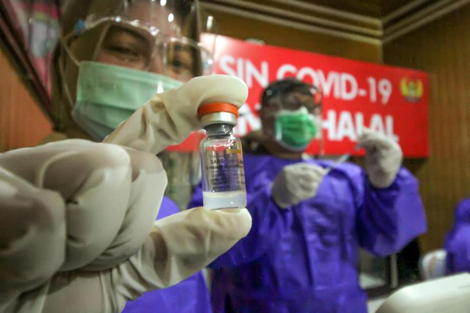 Petugas Kesehatan menunjukkan vaksin COVID-19 Sinovac saat vaksinasi tahap pertama di Rumah Sakit Kesrem, Lhokseumawe, Aceh. Rabu (10/2/2021). Vaksinasi perdana tersebut menandai dimulainya program vaksinasi COVID-19 dan selanjutnya dilakukan vaksinasi pa