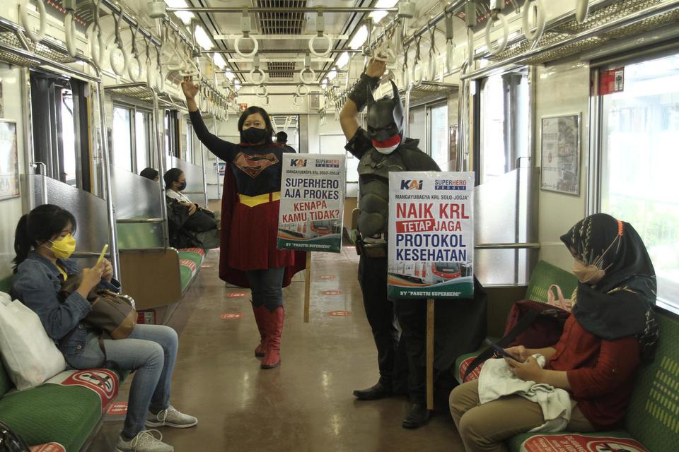 Warga berkostum superhero membawa poster ajakan mematuhi protokol kesehatan saat menaiki Kereta Rel Listrik (KRL) rute Solo-Yogya di Stasiun Yogyakarta, Gedongtengen, DI Yogyakarta, Kamis (11/2/2021). Aksi tersebut untuk mengajak masyarakat dalam memutus 