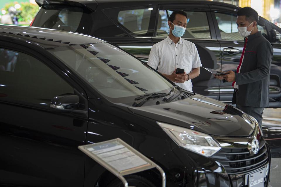 Karyawan menjelaskan salah satu produk mobil kepada calon pembeli di salah satu dealer di Jakarta, Senin (15/2/2021). Pemerintah memberikan keringanan pajak penjualan atas barang mewah (PPnBM) mobil baru ketegori 4x2 atau sedan dengan mesin sampai dengan 
