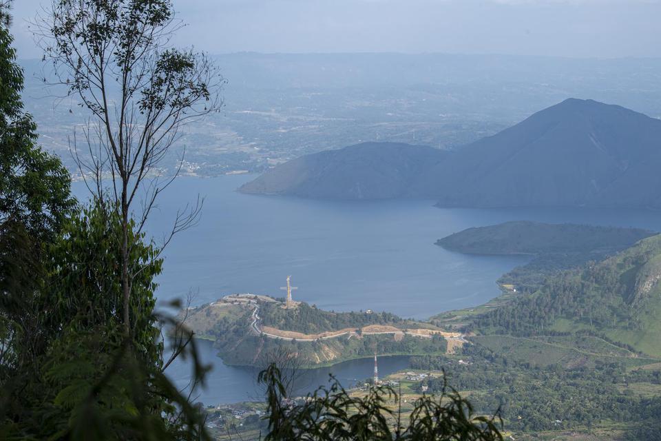 Foto aerial Danau Toba dari kawasan wisata menara pandang Tele di Turpuk Limbong, Harian, Kabupaten Samosir, Sumatera Utara, Minggu (21/2/2021). Wisata menara pandang tersebut menyajikan keindahan panorama Danau Toba hingga pegunungan Samosir dari atas ke