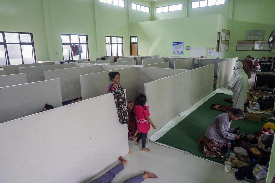Warga korban banjir beristirahat di bilik pengungsian Aula Kantor Kecamatan Pekalongan Barat, Jawa Tengah, Senin (22/2/2021). Badan Penanggulangan Bencana Daerah (BPBD) Kota Pekalongan memasang bilik sekat bagi pengungsi banjir untuk mengurangi resiko pen