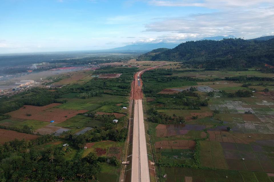 Foto udara pembangunan ruas jalan tol Padang - Pekanbaru di Nagari Kasang, Kabupaten Padangpariaman, Sumatera Barat, Jumat (26/2/2021). Pemerintah telah menyiapkan anggaran sebesar Rp821 miliar untuk membebaskan lahan Tol Padang-Pekanbaru seksi I sepanjan