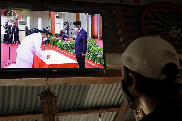 Warga menonton pelantikan sejumlah kepala daerah di Sulawesi Selatan melalui siaran langsung (live streaming) di Makassar, Sulawesi Selatan, Jumat (26/2/2021). 
